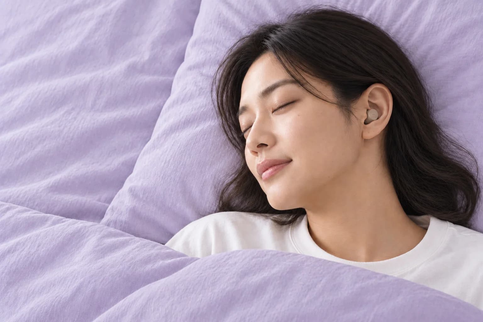 枕に横向きで顔を預ける女性
